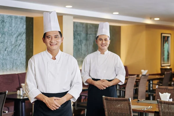 Retrato Dos Chefs Profesionales Uniforme Sombreros Sonriendo Cámara Mientras Están —  Fotos de Stock