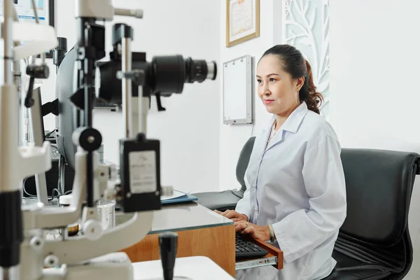 Asian Mature Female Doctor White Coat Sitting Table Working Special — Stockfoto