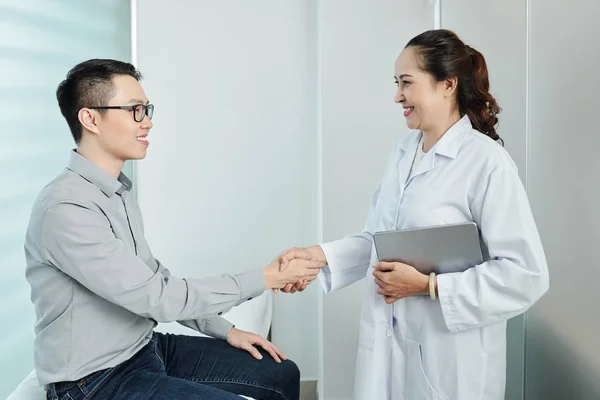 Asiatische Ärztin Weißen Mantel Hält Tablet Und Schüttelt Ihrer Patientin — Stockfoto