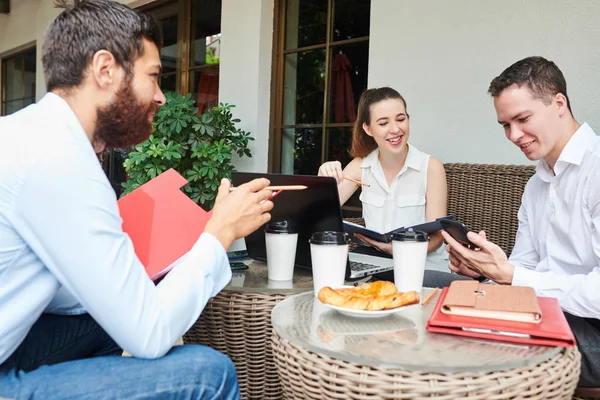 若い笑顔の起業家がカフェで同僚と会う際にスマートフォンでメッセージをチェック — ストック写真