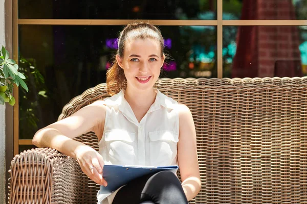 Happy Young Pretty Female Entrepreneur Sitting Wicker Couch Clipboard Her — Stockfoto