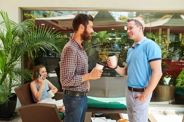 Glimlachende Jonge Mannen Drinken Afhaalkoffie Bespreken Nieuws Café Buiten — Stockfoto