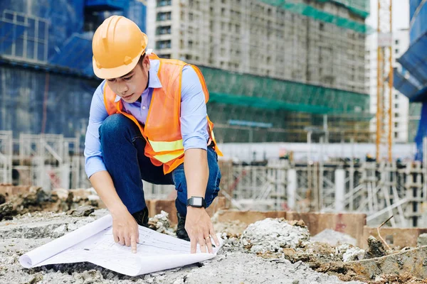 Vážný Vietnamský Dodavatel Oranžovém Hardhat Zkoumá Stavební Plán Při Práci — Stock fotografie