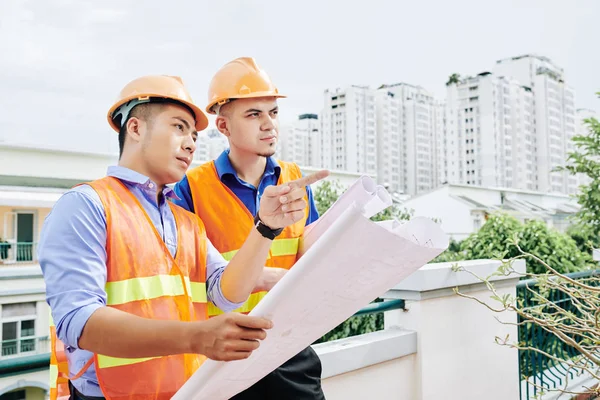 Trabajadores Construcción Serios Pie Aire Libre Con Proyecto Construcción Discutir — Foto de Stock