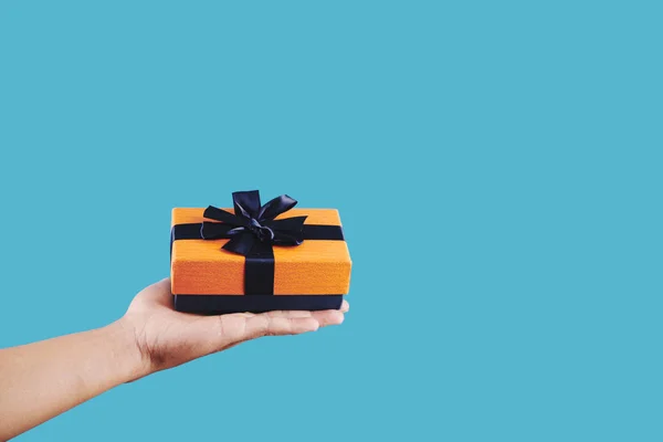 Main Avec Cadeau Enveloppé Dans Papier Bleu Orange Avec Grand — Photo