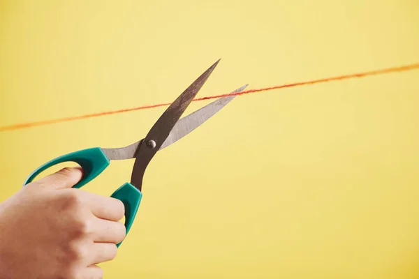 Person Schneidet Dünnen Roten Faden Mit Scharfer Schere — Stockfoto