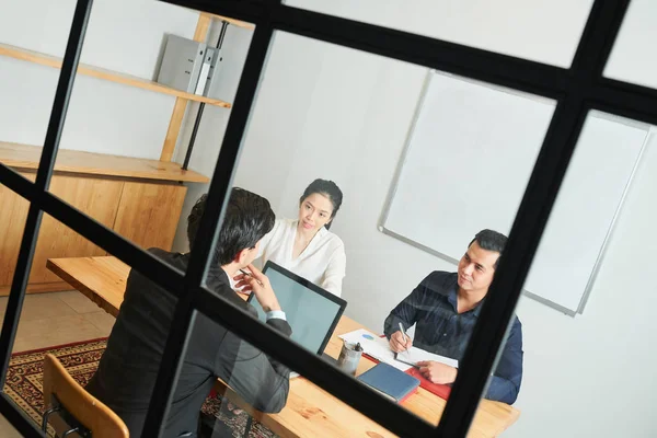 Parceiros Negócios Sentados Mesa Conversando Com Seu Líder Masculino Enquanto — Fotografia de Stock