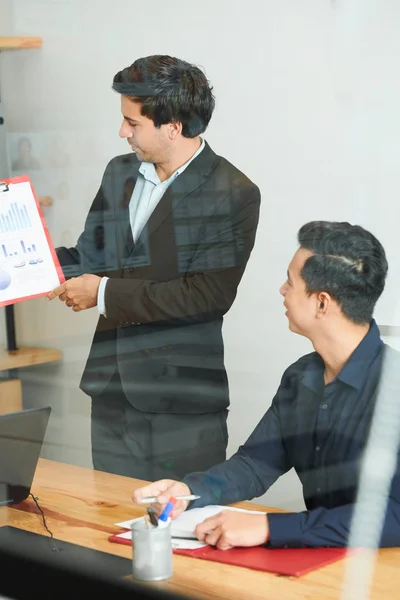 Joven Hombre Negocios Pie Sosteniendo Informe Financiero Presentándolo Sus Colegas — Foto de Stock