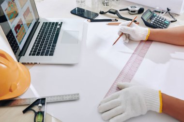 Tekstil eldivenleri mühendisi. Cetvel ve keskin kalemle inşa etme planı çiziyor.