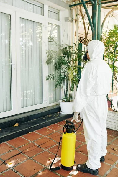 Teknisi Dalam Pakaian Hazmat Menyemprotkan Bahan Kimia Dinding Dan Jendela — Stok Foto