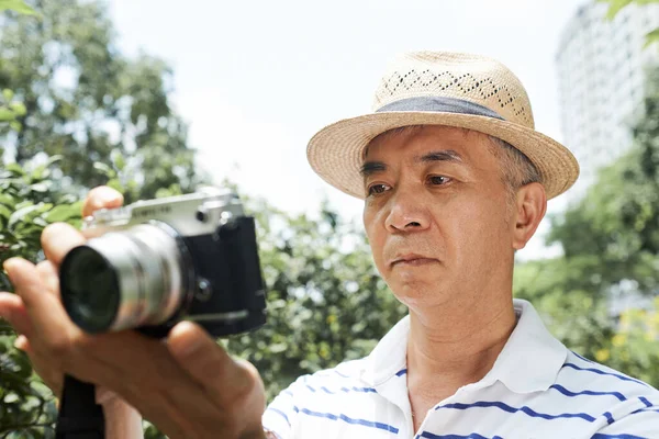 Senior Asiatisk Man Tittar Skärmen Sin Digitalkamera För Att Kontrollera — Stockfoto