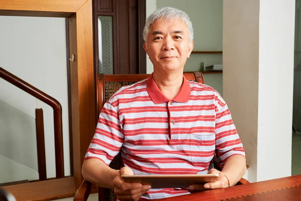 中国快乐的中老年人穿着条纹衬衫在家里的平板电脑上工作的画像 — 图库照片