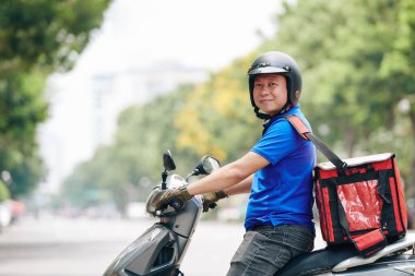 Büyük soğutucu çantalı neşeli Vietnamlı adamın portresi teslimat servisi için çalışıyor.