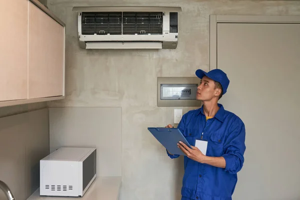 Junger Vietnamesischer Servicemitarbeiter Überprüft Geräte Wohnung Des Kunden — Stockfoto
