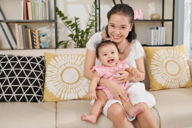 Genç anne, sevimli küçük kızıyla eğleniyor.