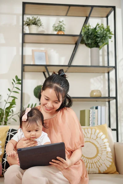 母親と彼女の小さな娘楽しみます楽しいゲームでタブレットコンピュータ上でホーム — ストック写真