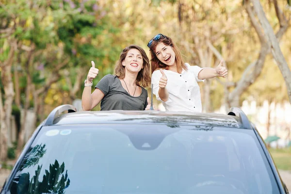 Podekscytowany Piękne Dziewczyny Przyjaciele Jazda Bagażniku Samochodu Pokazano Kciuki Góry — Zdjęcie stockowe