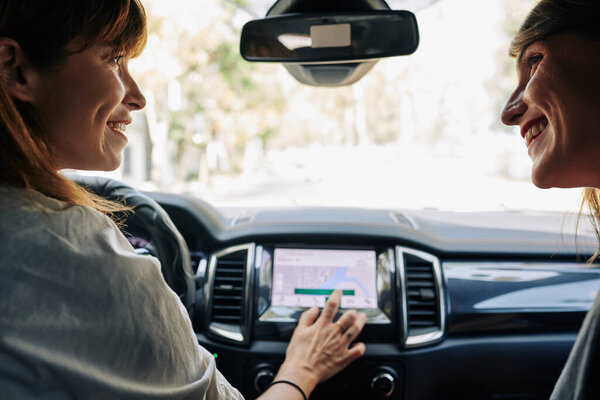 Веселые друзья устанавливают точку назначения на автомобиле GPS навигации
