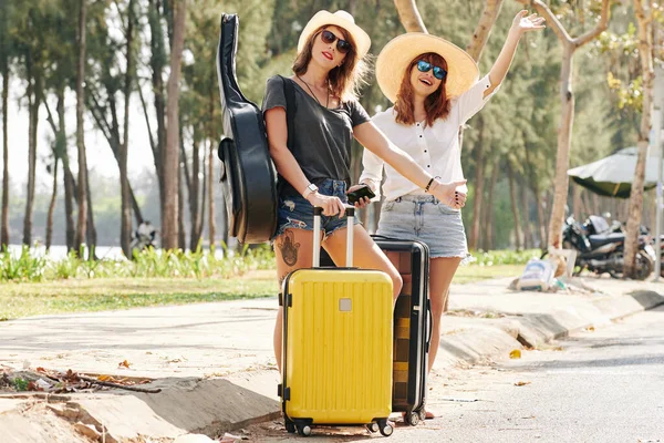 Fröhliche Junge Frauen Mit Koffern Fangen Autos Auf Wenn Sie — Stockfoto