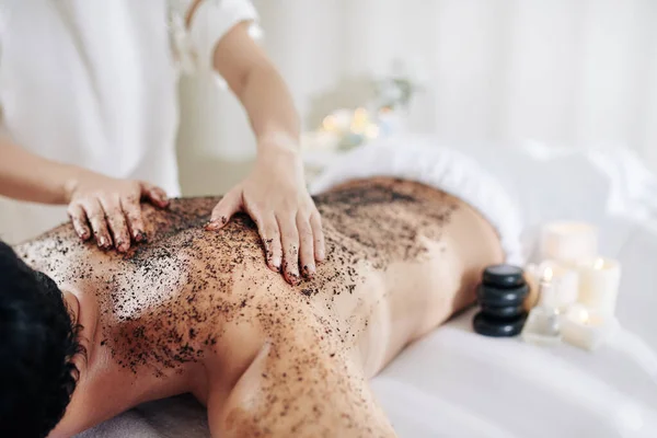 Kosmetolog Tillämpa Kaffe Peeling Baksidan Manliga Klienten Före Massage — Stockfoto