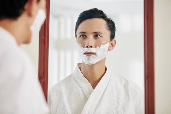 Joven Hombre Raza Mixta Mirando Espejo Baño Aplicar Crema Ahorro —  Fotos de Stock