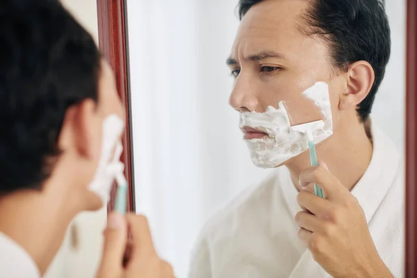 Sério Homem Franzindo Testa Olhando Para Espelho Fazer Barba Manhã — Fotografia de Stock