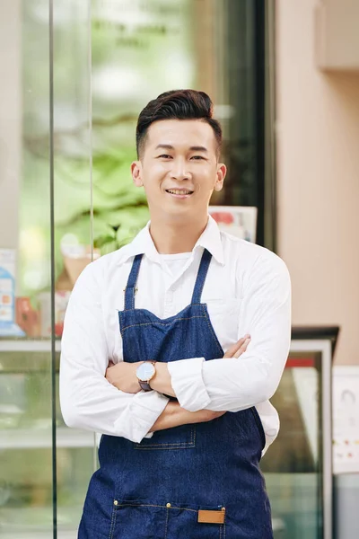 Retrato Garçom Sorrindo Positivo Denim Avental Frente Café Com Braços — Fotografia de Stock