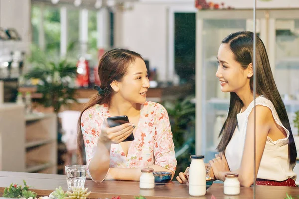 美しい若いアジアの女性の友人がカフェテーブルで朝食を取り 最新のニュースや噂話を議論 — ストック写真