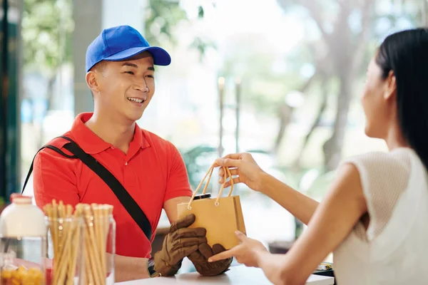 Glimlachende Koerier Uniform Neemt Ingepakte Bestelling Uit Handen Van Cafe — Stockfoto