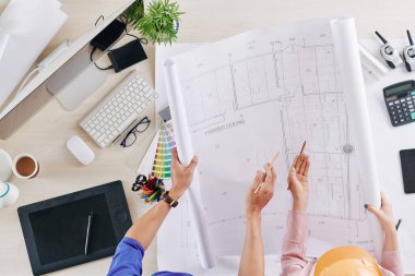 Mühendisler evin planlarını hazırlıyorlar ve ayrıntıları tartışıyorlar, yukarıdan görünüm