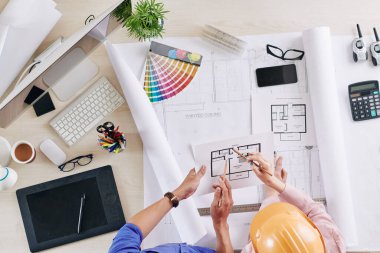 Mühendis ve mimar, bina planı, grafik tablet ve renk paleti ile bir araya geldiğimizde apartman planlarını tartışıyorlar.