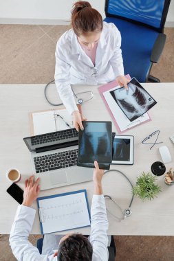 Hemşire hastanın röntgenini akciğer uzmanına veriyor.