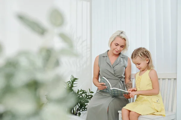 Sonriente Joven Madre Mostrando Interesante Libro Pequeña Hija — Foto de Stock