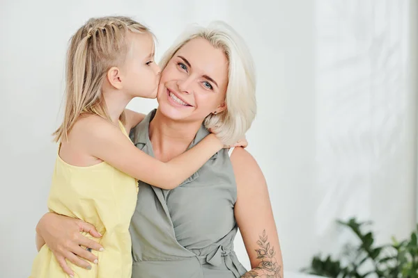 Cute Little Girl Hugging Kissing Her Smiling Mother Cheek — Stock Photo, Image