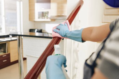 Ev hanımı merdivenleri dezenfekte spreyiyle siliyor.