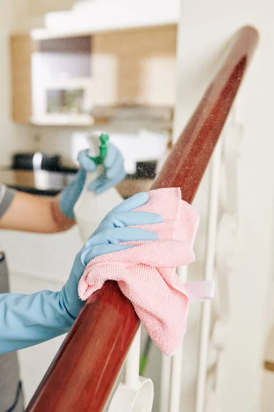 階段の手すりに木の洗剤を適用し 柔らかい布でそれを拭く女性 — ストック写真