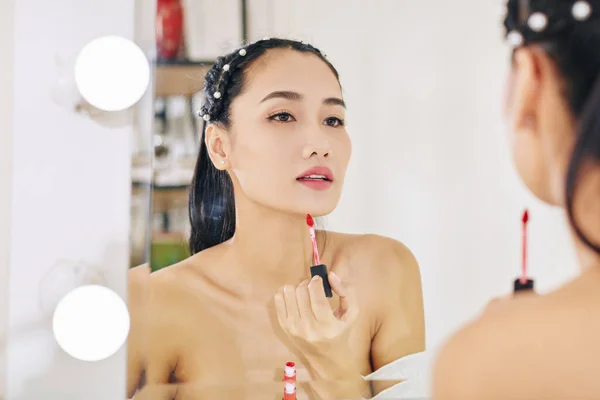 Güzel Genç Asyalı Kadın Aynaya Bakıyor Kırmızı Dudak Parlatıcısı Sürüyor — Stok fotoğraf