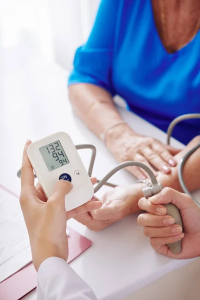 Hände Des Hausarztes Mit Elektronischem Tonometer Bei Blutdruckkontrolle Von Seniorin — Stockfoto