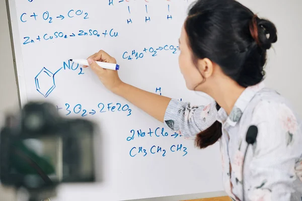 化学教師はホワイトボード上に化学元素の構造を描く — ストック写真