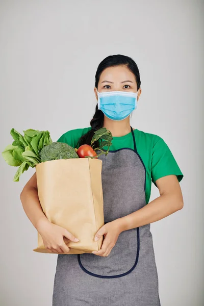 Supermarkt Angestellte Schürze Und Medizinischer Maske Hält Papierverpackung Mit Frischen — Stockfoto