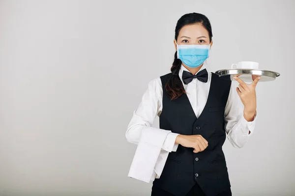 亚洲餐馆女服务员戴着医疗面罩为食物服务的肖像 — 图库照片