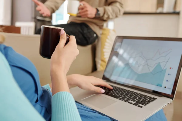 Kanapén Elemzi Pénzügyi Diagramot Laptop Képernyőjén Kávét Iszik Beszél Férjével — Stock Fotó