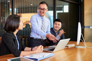 Modern ofis yönetim kurulu odasında meslektaşlarına istatistikleri gösteren profesyonel iş analisti.