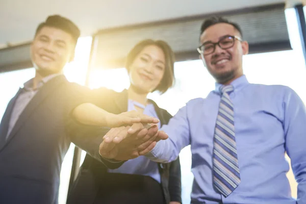 Grupa Trzech Azjatyckich Biznesmenów Łączących Ręce Wykonując Gest Jedności Symbolizujący — Zdjęcie stockowe