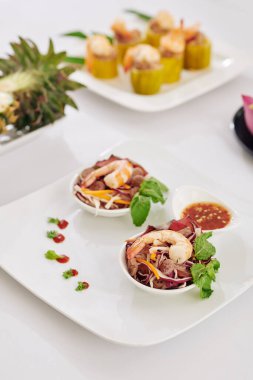 Kare tabakta karides salatası ile akşam yemeği için pişirilmiş küçük bir kase.