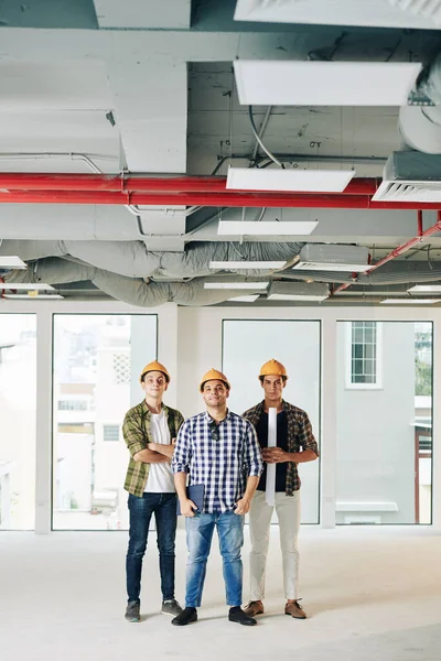 Vertical Tiro Longo Três Engenheiros Profissionais Vestindo Camisas Verificadas Hardhats — Fotografia de Stock