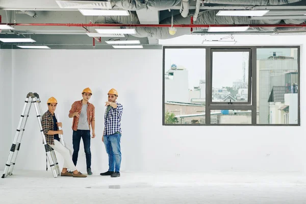 Groupe Ingénieurs Construction Qui Coopèrent Dans Une Salle Bâtiment Spacieuse — Photo