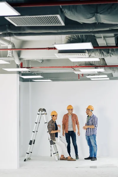Vertical Tiro Longo Três Engenheiros Construção Profissionais Reunidos Sala Inacabada — Fotografia de Stock