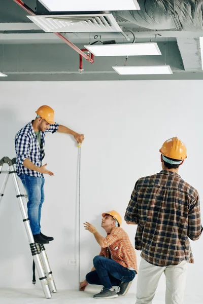 Plano Vertical Trabajador Construcción Profesional Pie Escalera Celebración Regla Cinta —  Fotos de Stock