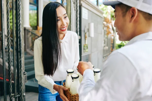 一位快乐的年轻亚洲女人拿着早上送来的奶瓶 肩头朝天地打针 — 图库照片